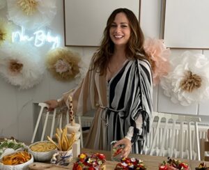 A woman smiling in a kitchen.